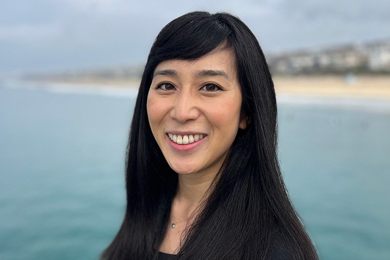 headshot of Rosanna Xia with the sea and a shoreline behind her