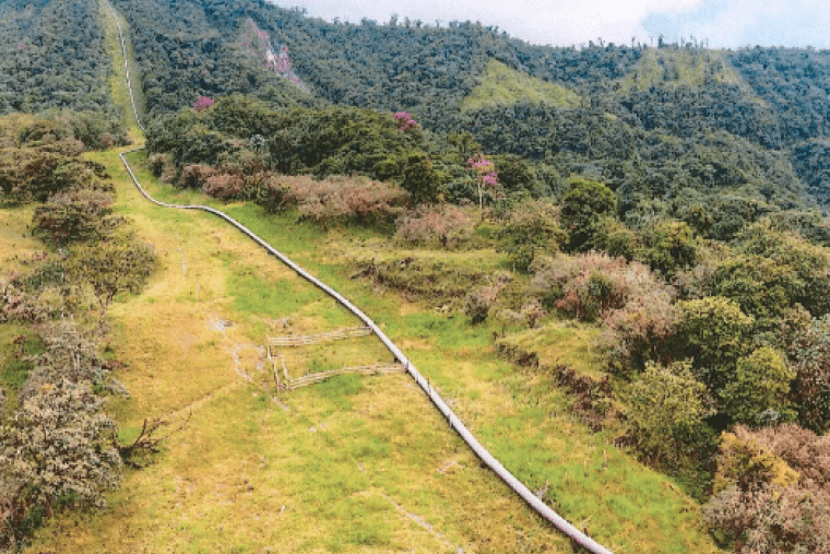 an oil pipeline snakes through an idyllic mountain landscape