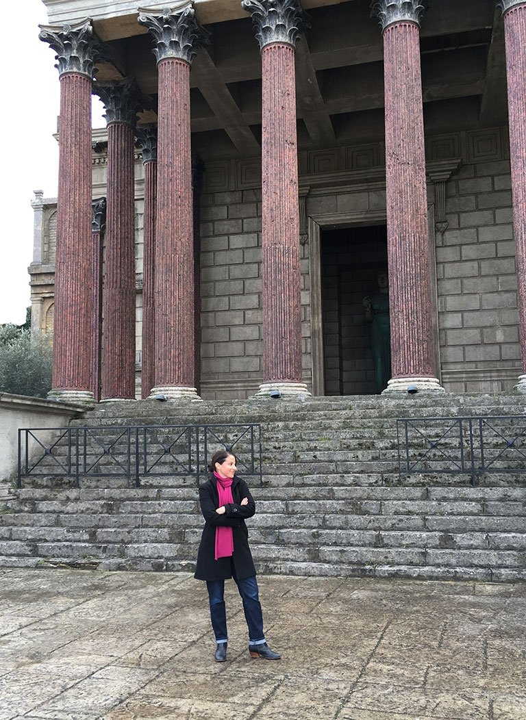 an image of michelle berenfeld standing in front of architectural columns