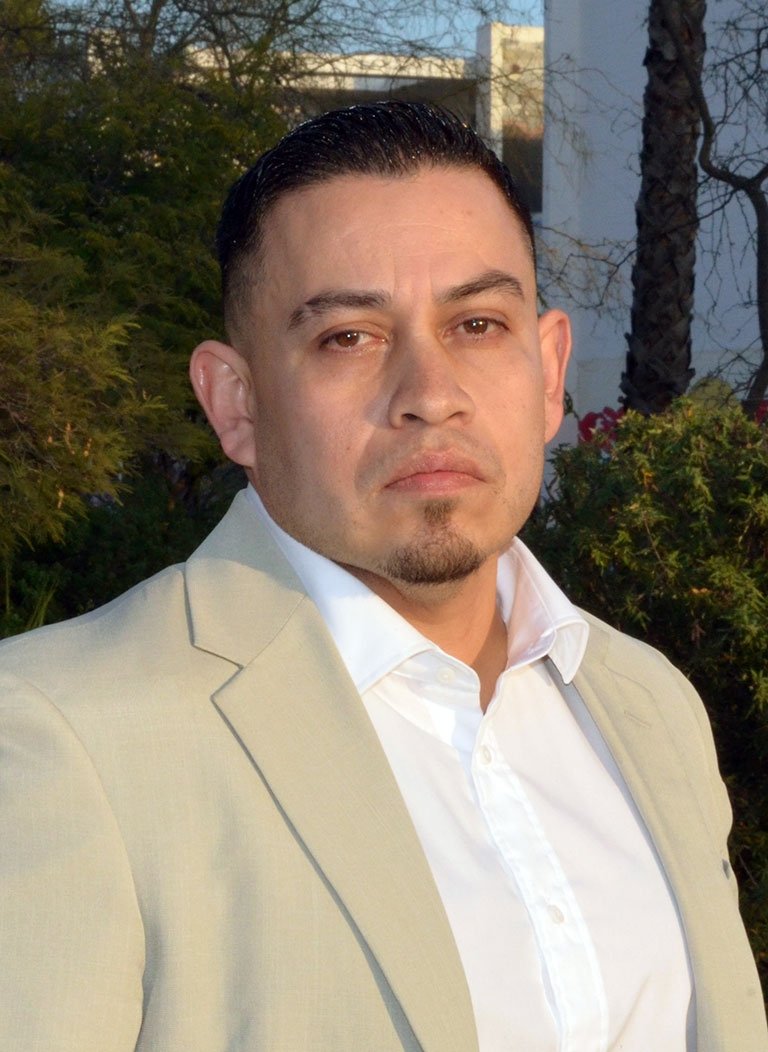 portrait of Bernie Hernandez  wearing a white collared shirt and beige blazer