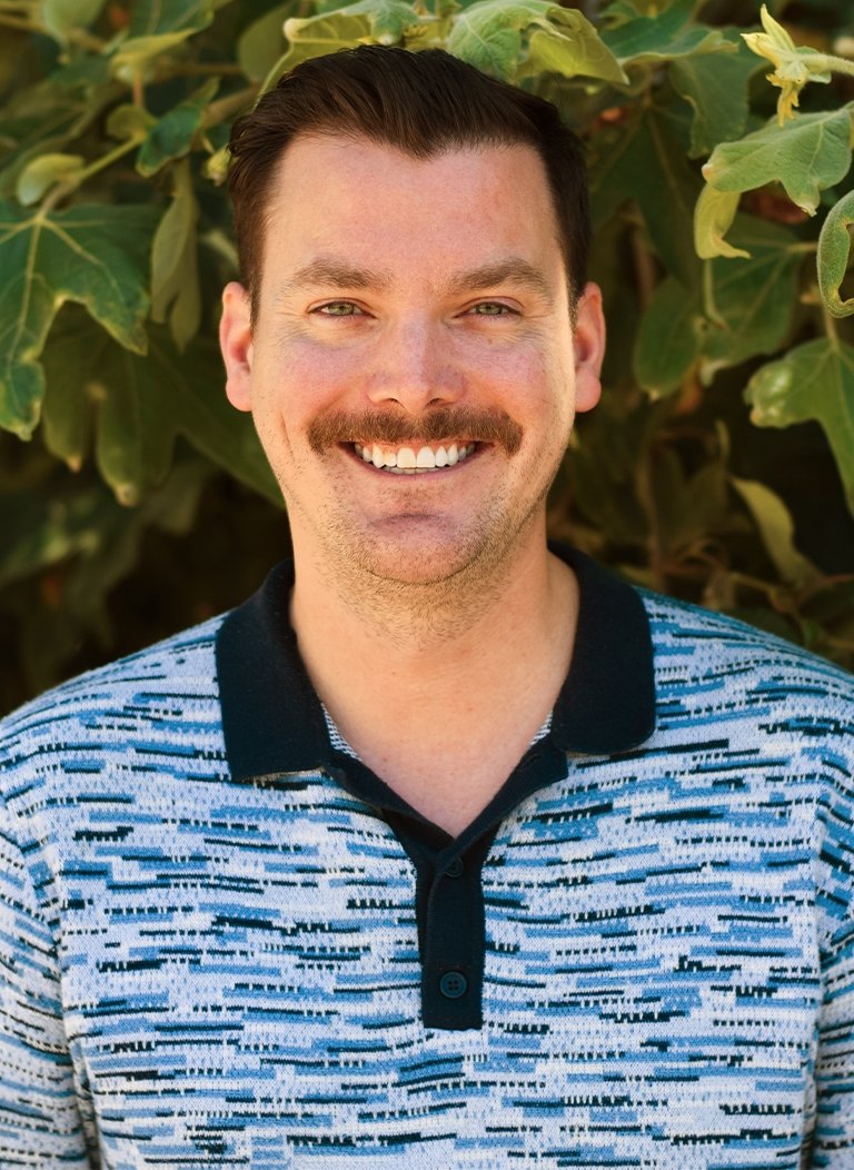 Man with blue collar shirt and brown short hair.
