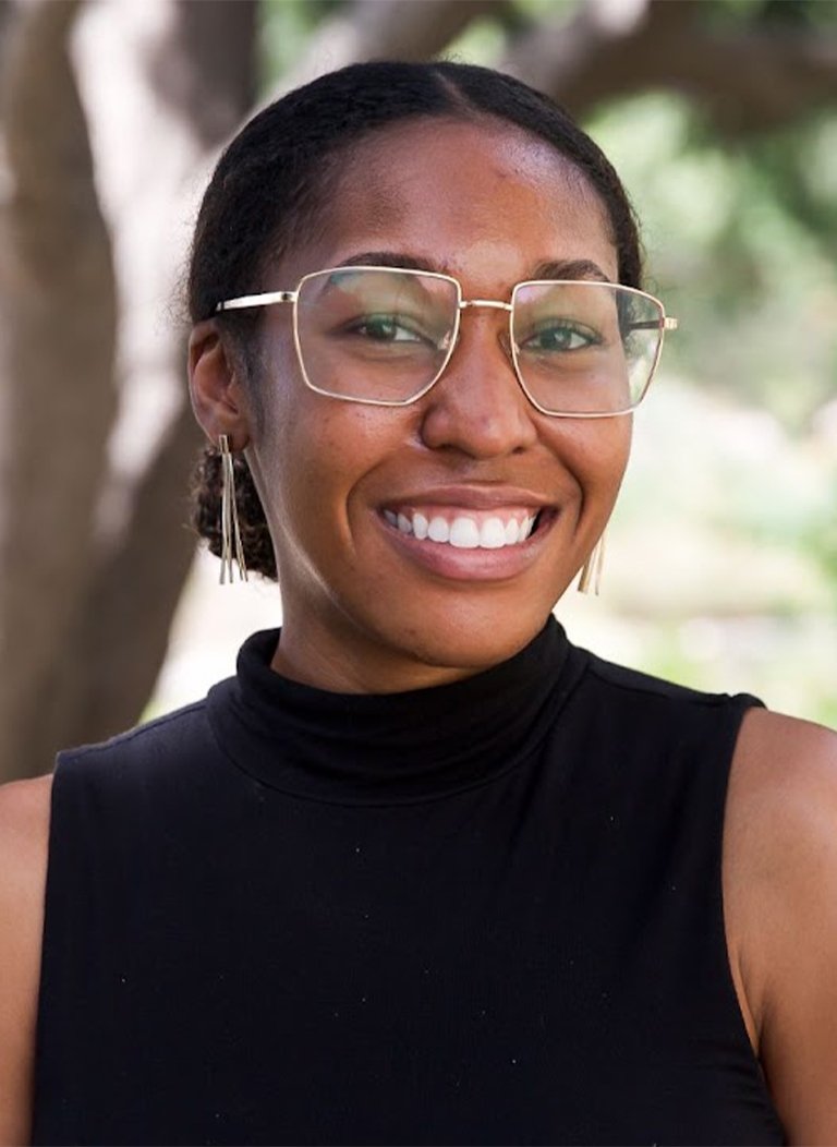 Woman in black top wearing glasses in short brown hair.