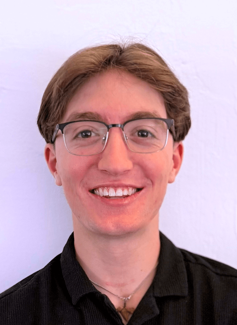 Student in black shirt wearing glasses with blonde hair. 
