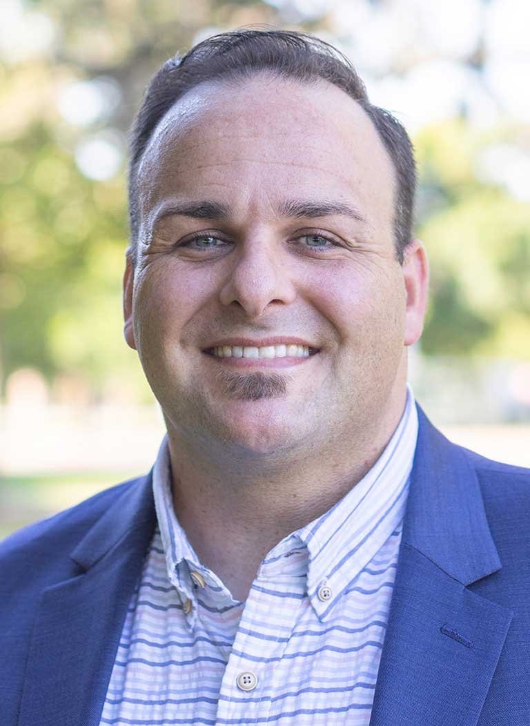 headshot of Kyle Smith in an outdoor setting