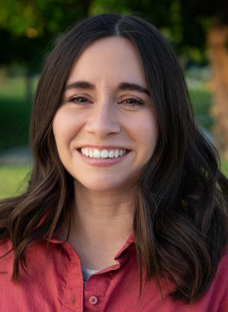 Woman with short brown hair wearing red blouse. 