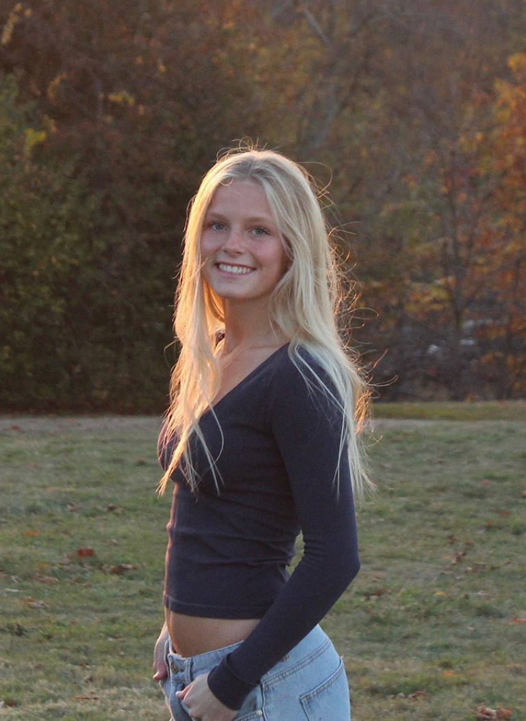 Birdie Hawkins stands in front of a field during sunset