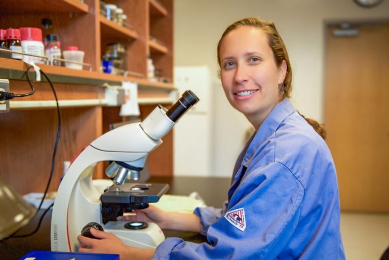 Tessa soloman-lane sits in front of a microscope