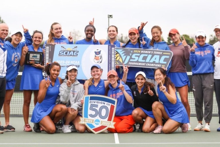 women's tennis team poses on the court