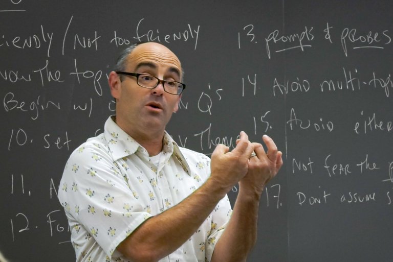 phil zuckerman lectures in a classroom while being filmed