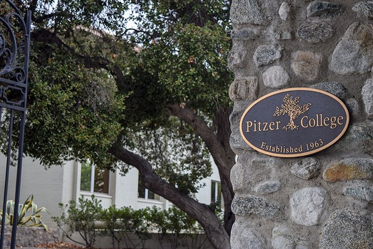 A closeup of the the Pitzer College bronze plaque on the stone pillar of the Pitzer Gate