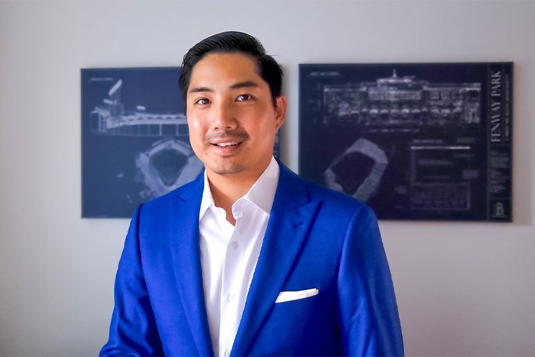 Closeup of James Kang, who has short black hair and wears a blue blazer over a white collared shirt.
