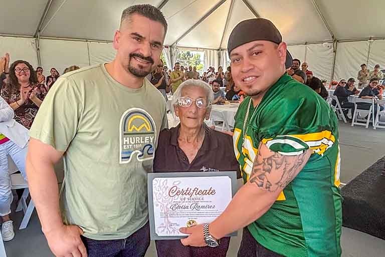 two pitzer staff members pose with Eloisa Ramirez and her certificate at the staff recognition lunch