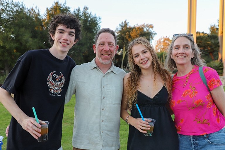 two students pose with their parents on Brandt Field during Pitzer's Family Weekend 2025