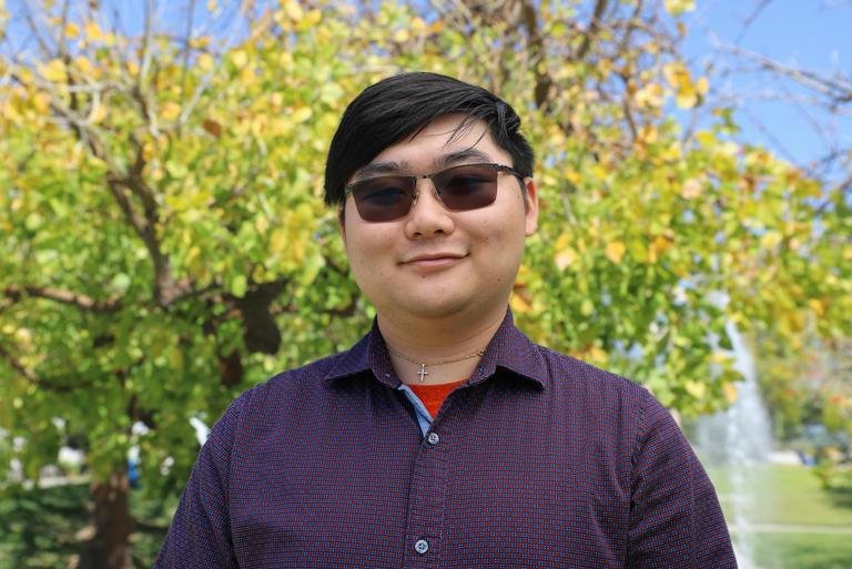 Robinson Lee stands in front of the fountain on the mounds