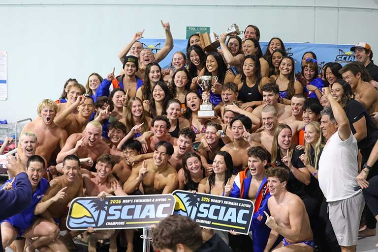 a team cheers and holds up a SCIAC sign