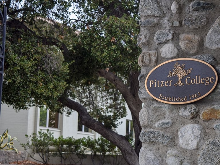 A closeup of the the Pitzer College bronze plaque on the stone pillar of the Pitzer Gate