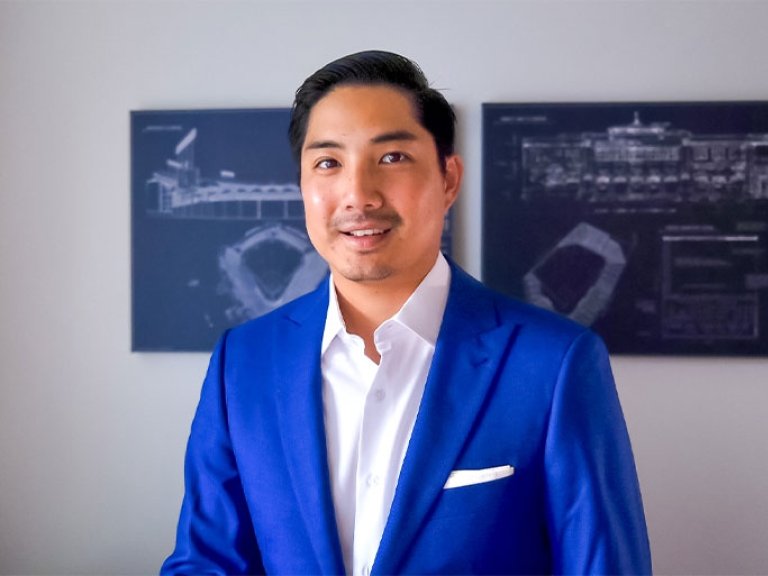 Closeup of James Kang, who has short black hair and wears a blue blazer over a white collared shirt.