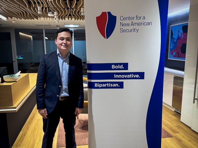 Cary Dornier stands next to a banner for the Center for a New American Security.