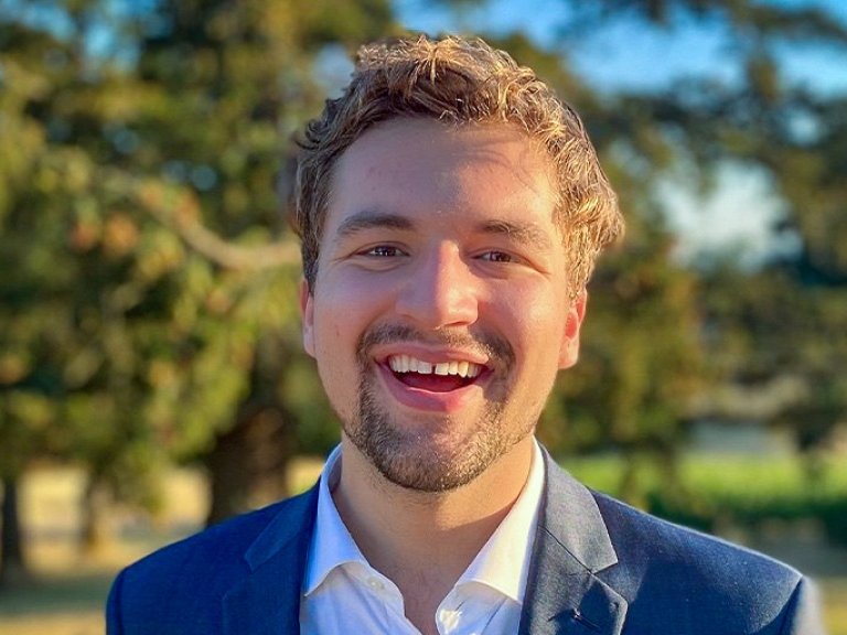 Aidan Henrikson has short blond hair and a light beard and wears a blue blazer over a white shirt.