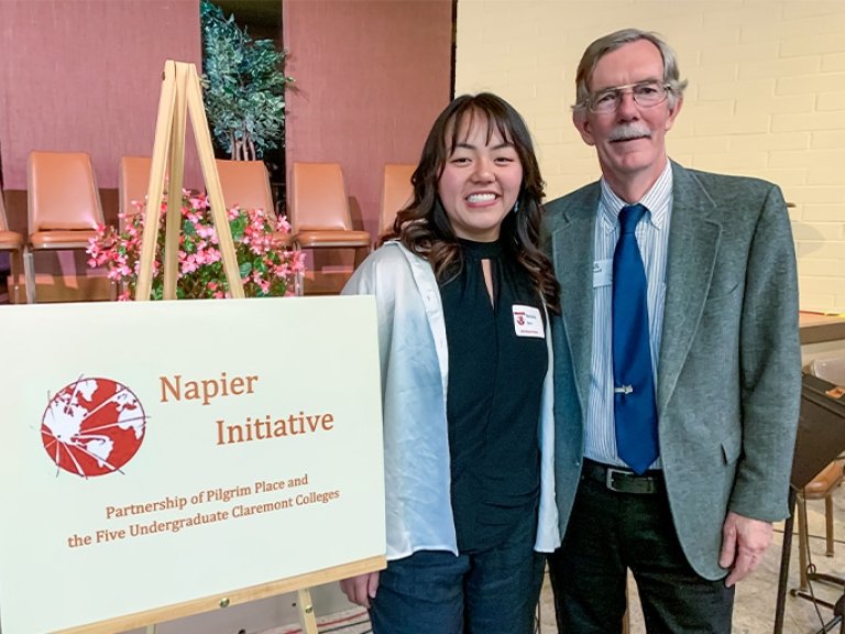Natasha Yen stands with her mentor Paul Cromwell at the Napier Award ceremony. To their right is a sign that says Napier Initiative.