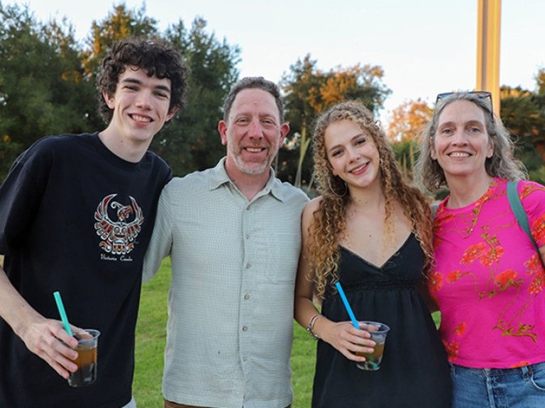 two students pose with their parents on Brandt Field during Pitzer's Family Weekend 2025