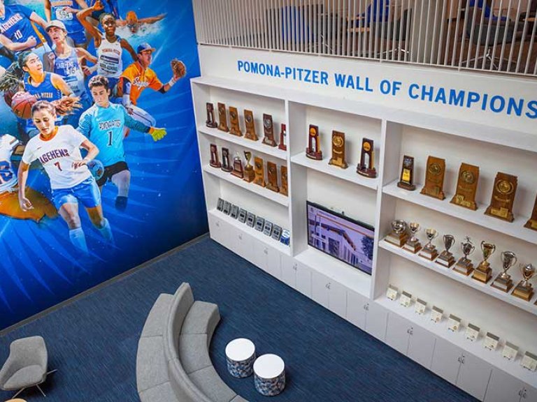 a wall of trophies with the words "Pomona-Pitzer" Wall of Champions" at the top