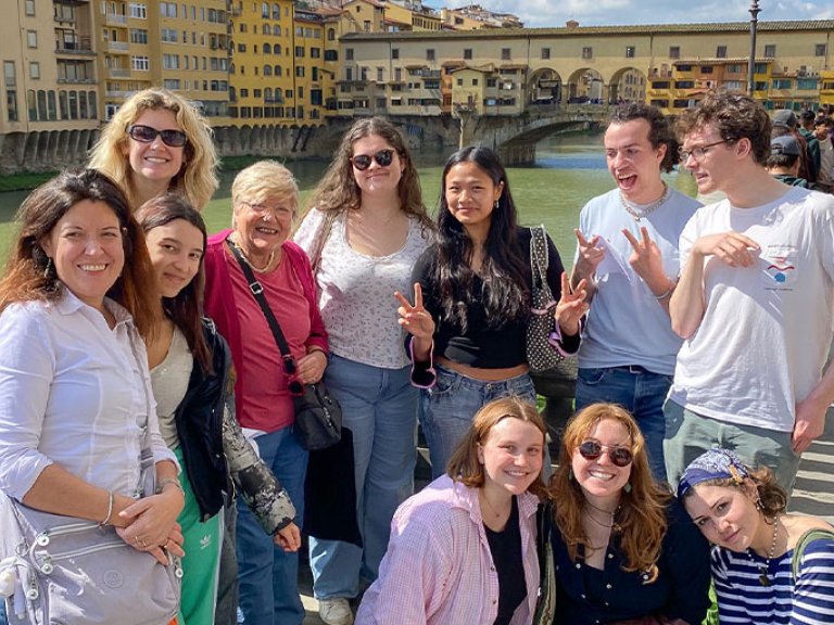 a group of students pose near a river