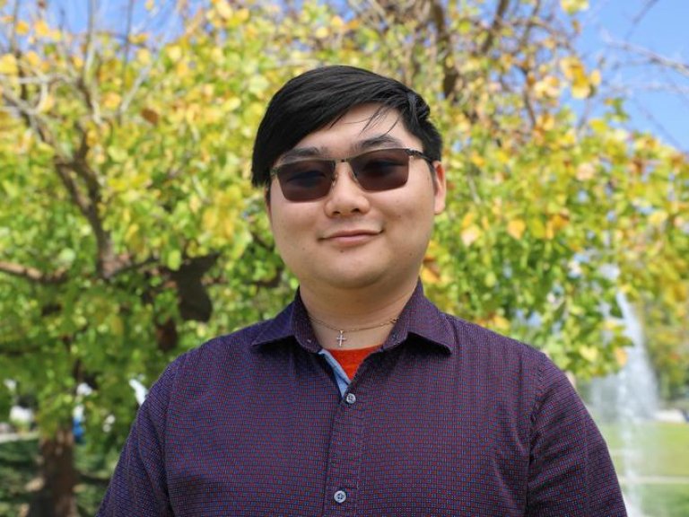 Robinson Lee stands in front of the fountain on the mounds