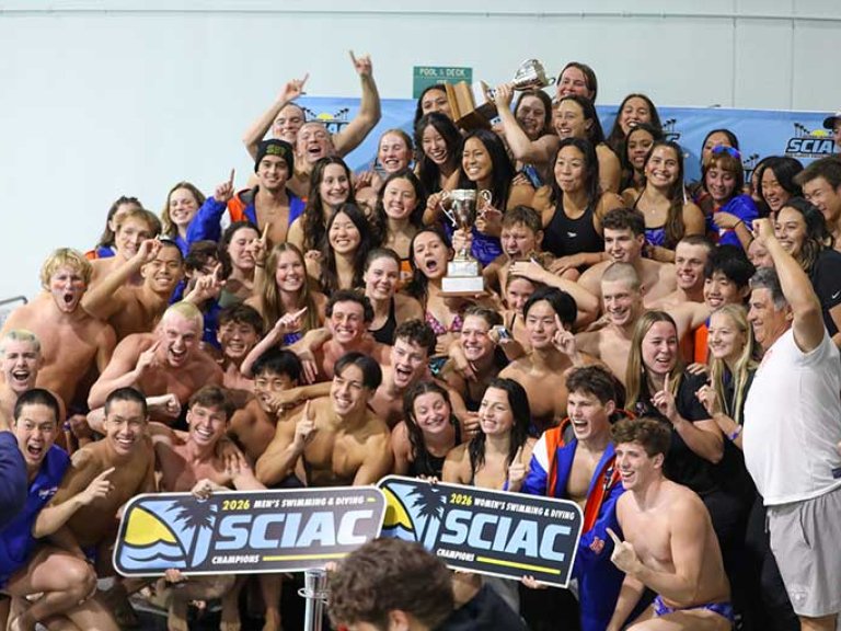 a team cheers and holds up a SCIAC sign