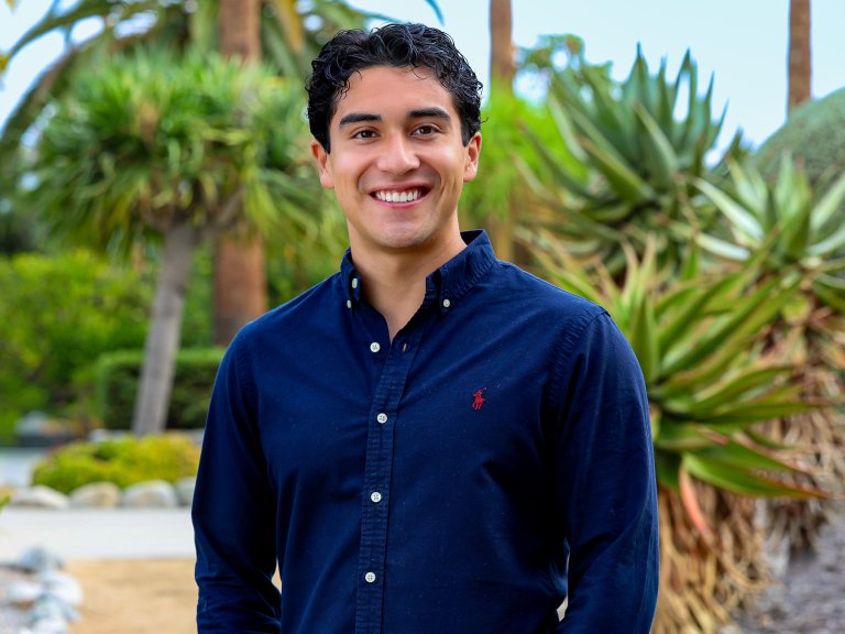 Sebastian maldonado standing in front of trees on the Pitzer campus
