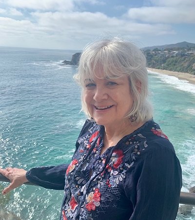A photo of an elderly Diane Shammas with an unknown coast in the background