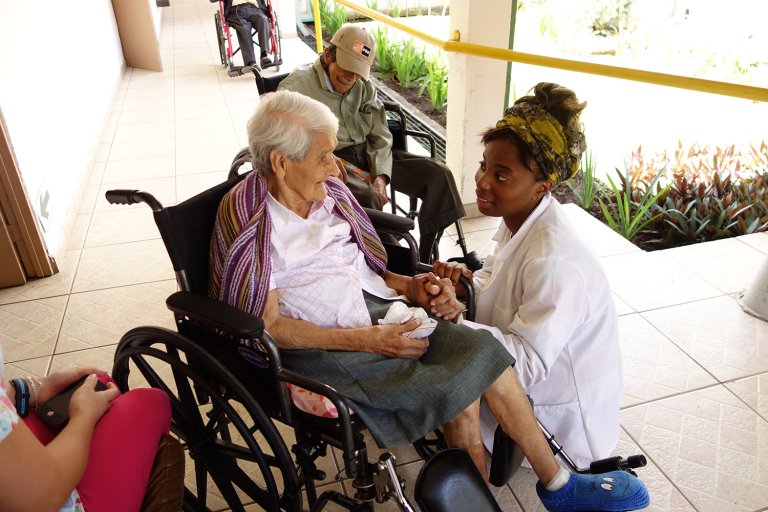 A Pitzer student helps a person in a wheelchair