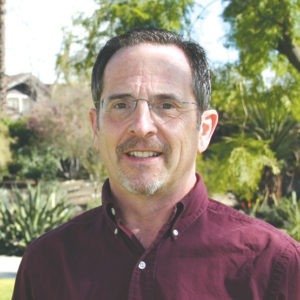 Headshot of Peter Nardi, who has short dark hair and wears glasses and a maroon collared shirt.