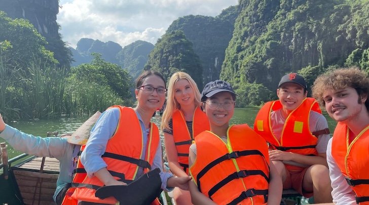 Group of students on boat in life jackets in Vietnam