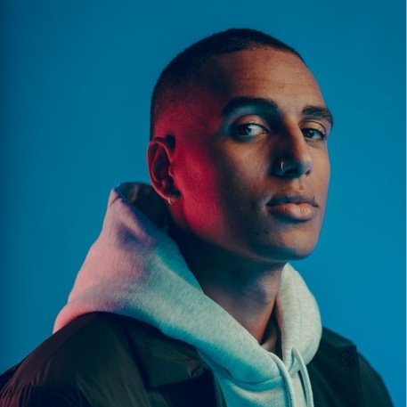 Headshot of Adrian Brandon, who has close-cropped dark hair and wears a gray hoodie.