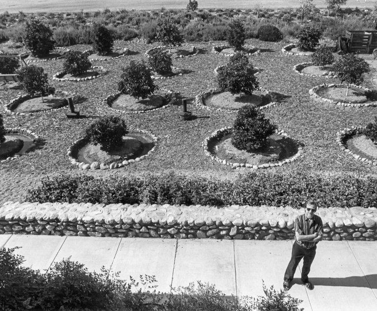 photo of John Rodman in stripped shirt in front of the Grove plants