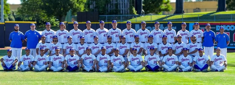 The Pomona-Pitzer men’s baseball team gathers on the field in two rows with their coaches for a group photo.