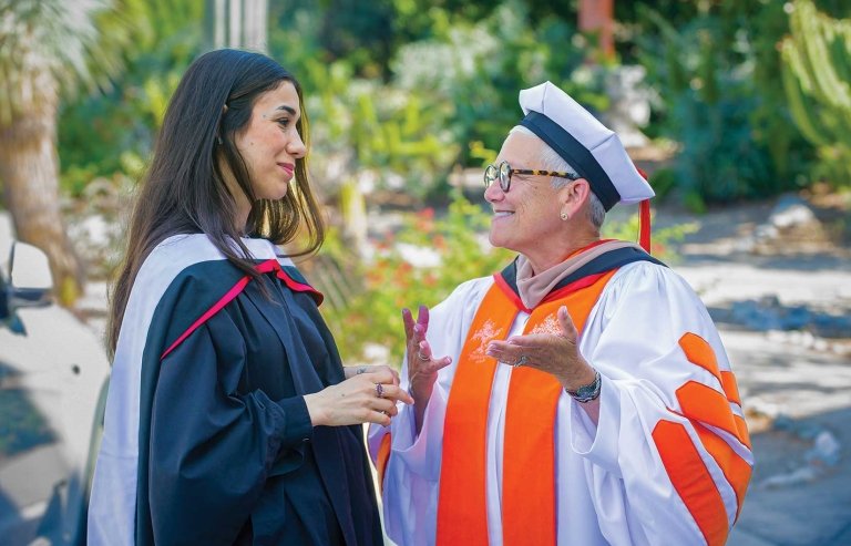 nadia murad and speaker wearing black and white, talking to each other