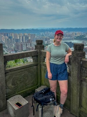 Jana Biedenweg stands at a balcony that is overlooking a cityscape in China.