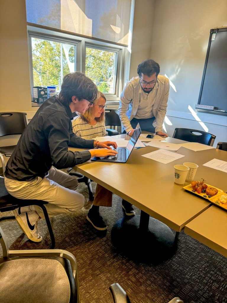 Isabelle Thacker works with two student volunteers on refugee green card applications