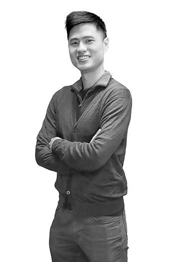 portrait of a man with short brown hair wearing a cardigan and jeans