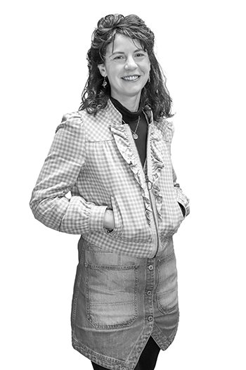 a woman wears a ruffled zippered jacket and a jean skirt