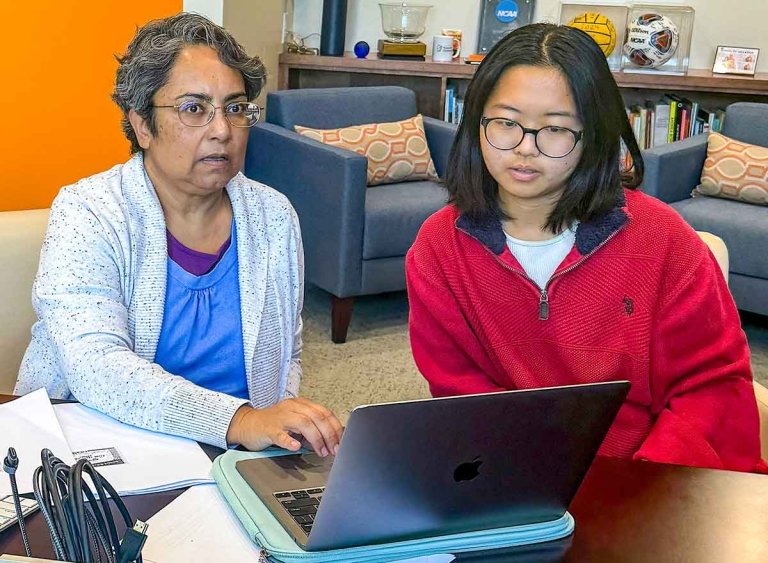 professor bhattacharya sits with a student at a laptop computer