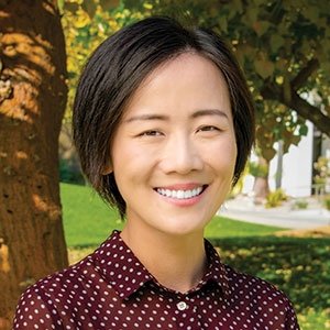 a woman with short brown hair wears a polka dot button up blouse