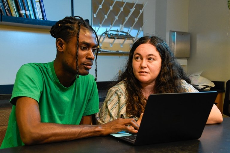 richard ampah sits next to professor sarah marzen at a laptop computer