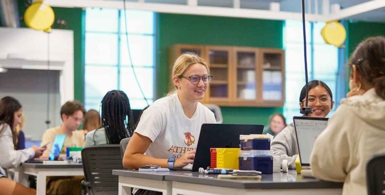 three student collaborate at desks in lab
