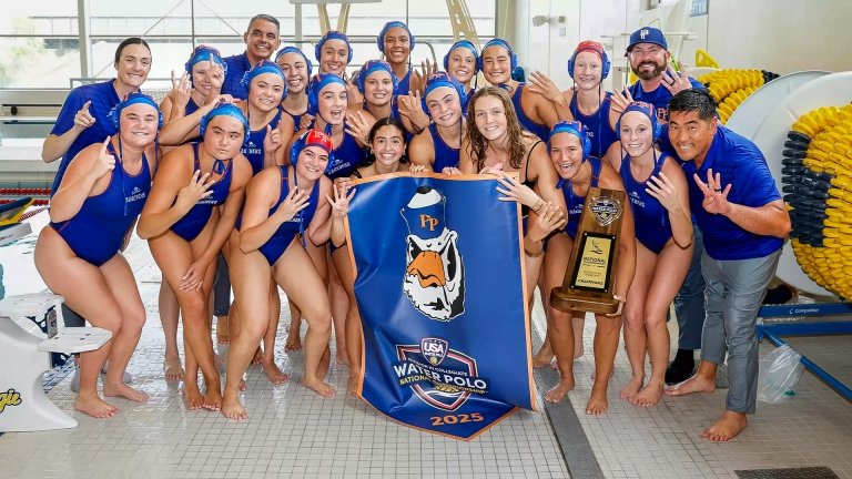 The Pomona-Pitzer women’s water polo team stands with their coaches by the pool with a banner of Cecil the Sagehen and a national trophy.