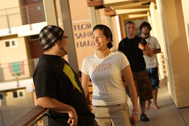 students greet each other on an outdoor hallway in PAS Hall