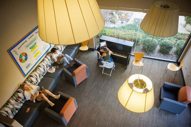three students relax on couches in a one of the PAS study rooms