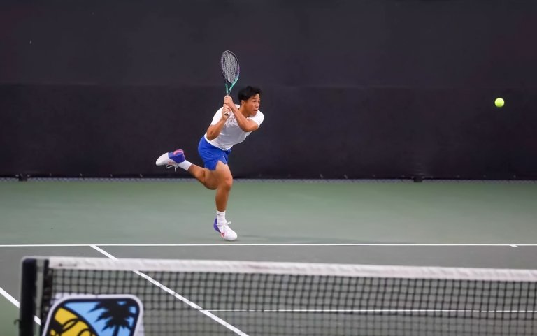 A Pomona-Pitzer men’s tennis player swings a racket on the court.